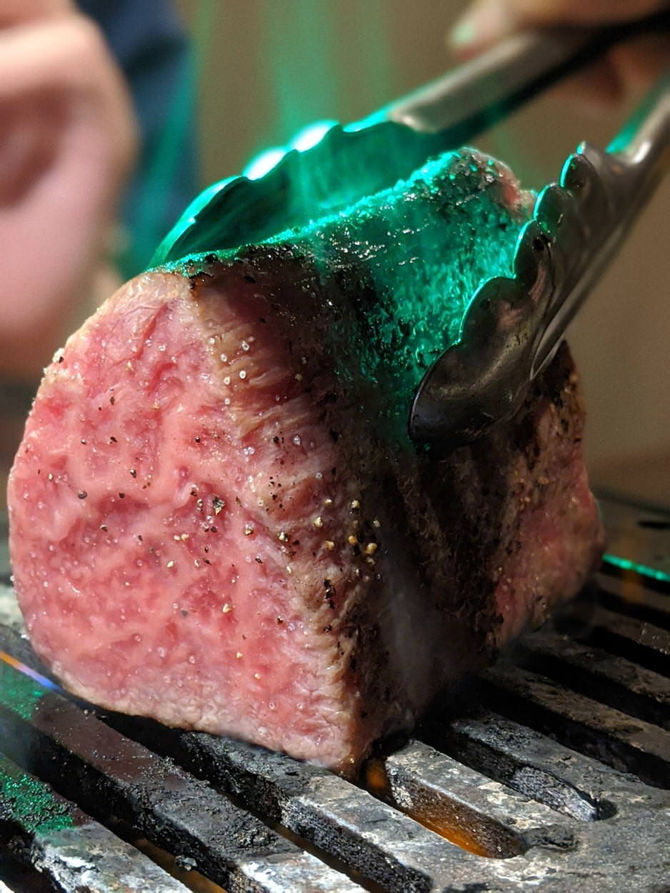AF補助光で緑色に燃え上がる肉の写真